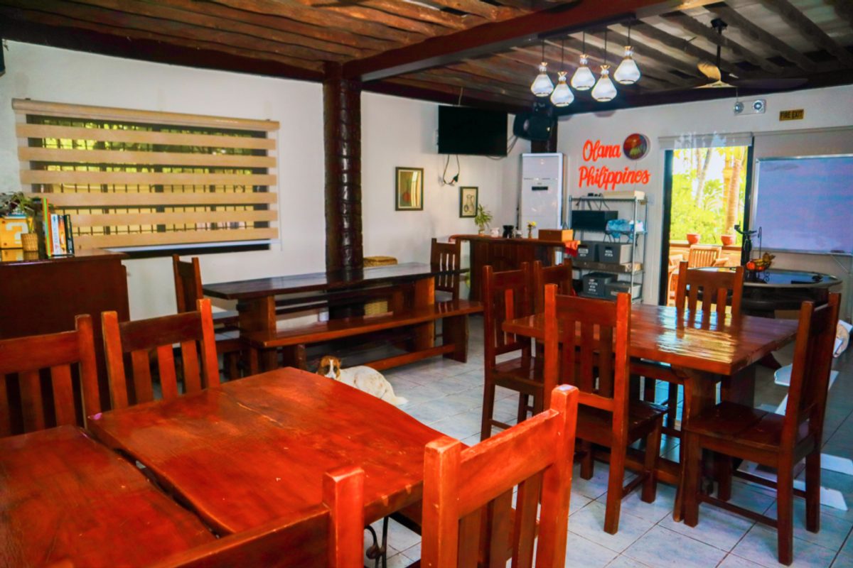 the dining room at Olana, its wooden tables and benches under a beamed ceiling